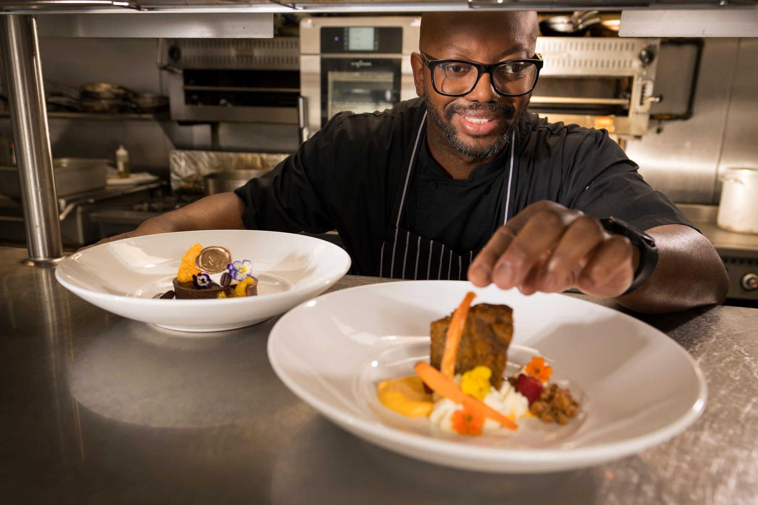A Mirabella at ASU chef finishes a dish with a gourmet garnish.